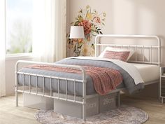 a white metal bed frame in a bedroom with flowers on the wall and rugs