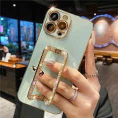 a woman holding up her phone case with an image of a gold ring on it