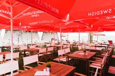 an outdoor dining area with red umbrellas and wooden tables