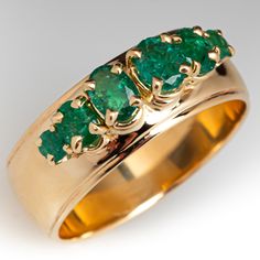 The lovely ring is accented with four (4) oval mixed cut natural emeralds and two (2) round mixed cut natural emeralds set into four-prong settings. The band measures 8mm wide. The band rises 6.2mm above the finger at the top and tapers to 1.4mm thick at the bottom. It is currently a size 10.25. The inside of the shank is engraved "RLM May 1969." Green 14k Gold Emerald Ring Collectible, Exquisite 14k Gold Green Emerald Ring, Elegant Multi-stone Emerald Ring In 14k Gold, 14k Gold Multi-stone Emerald Ring As A Gift, 14k Gold Emerald Ring With 17 Jewels - Collectible, Emerald Band Ring, Texture Jewelry, Emerald Band, Ring Setting