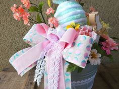 a basket filled with lots of different colored flowers and ribbons on top of a wooden table