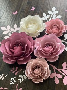 pink and white paper flowers sitting on top of a wooden table