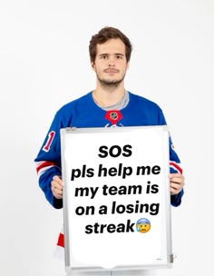 a man holding a sign that says sos plis help me my team is on a losing streak