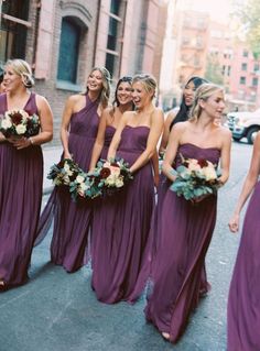 a group of women in purple dresses standing next to each other