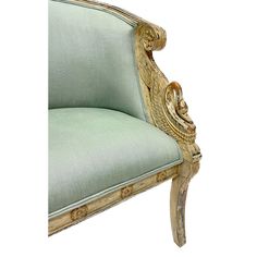 an ornately carved arm chair with green upholstered fabric and gold trimmings