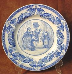 a blue and white plate with an image of two children in the woods on it