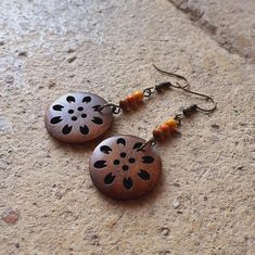 Are you looking for an original and creative gift for someone special? Do you like unique and handmade accessories?  Then don't miss these earrings made with rustic style wooden buttons.  These earrings are the perfect accessory for any occasion, as they go with everything and add a touch of personality to your look.  Two models:  - Model 1- orange central bead.  - Model 2- red central bead.  In both models, the hook is hippie style in antique bronze color. 🔺 To keep them in perfect condition f Handmade Natural Wood Earrings, Bohemian Brown Wooden Earrings, Handmade Wooden Drop Earrings, Handmade Wood Drop Earrings, Handmade Artisan Wood Earrings, Bohemian Wooden Bead Earrings, Artisan Wood Handmade Earrings, Artisan Brown Wooden Earrings, Handmade Brown Nature-inspired Earrings