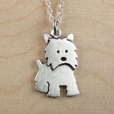 a small silver dog pendant on a chain