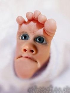 a close up of a baby's face with one hand on the top of his head