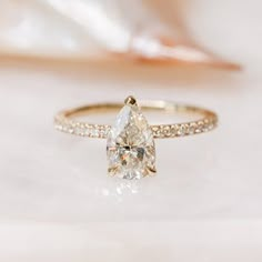 an engagement ring with a pear shaped diamond