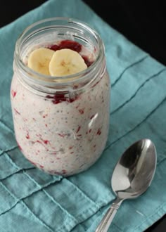 a glass jar filled with food next to a spoon on top of a blue napkin