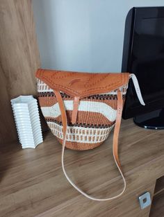 "Brown and white sisal tote bag with leather flap DIMENSIONS Bottom width: 10\" Top width: 14\" Depth: 10\" Straps: 15\" SHIPPING All orders ship via DHL Express (3-5) days delivery time." Woven Handbags, Maasai, Hobo Bag, Handmade Bags, New Bag, Hand Weaving, Handbags, Etsy Accessories, Tote Bag