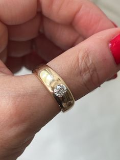 a woman's hand with a gold and diamond ring on it