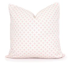 a pink and white pillow with small flowers on the front, against a white background