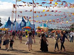 many people are walking around at an outdoor festival