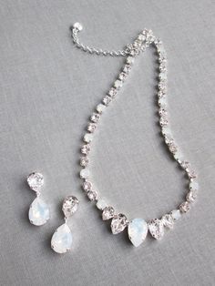 "This elegant necklace and the earrings set is hand made using fine Swarovski crystals in white opal and clear crystal mix. The necklace measures 16\" long and comes with the 2\" extender. The matching drop earrings measure 1 1/2\" long and 1/2\" wide. The set is available in gold, silver or rose gold finish. Also available with all clear crystals. - The listing is for the jewelry set only - For the matching belt please take a look here: https://www.etsy.com/listing/751689969/swarovski-crystal-b White Dangle Jewelry Sets For Formal Occasions, Formal White Jewelry Sets With Sparkling Stones, Exquisite White Cubic Zirconia Jewelry Sets, Fine Jewelry White Crystal Jewelry Sets, White Sparkling Stones Jewelry Set For Wedding, Elegant Crystal Embellished Jewelry For Gifts, Fine Jewelry Crystal Jewelry Sets In White, Elegant Teardrop Stone Jewelry, White Crystal Fine Jewelry Sets