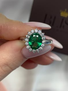 Oval Cut Diana Model Ring - Lab Created Emerald Green Gemstone With 0,30 ct Diamonds Around - 18K White Gold This model is named after princess Diana which had an unexceptional royal taste - can be used as a gift and some use it as an engagement ring as well - Ring details - Center Stone - 2,00 ct Oval Cut Emerald Gemstone - Check out the Green Color in the video Excellent Graded Cut Side Stones - 1,60 ct Total Round Brilliant Cut Natural Diamonds Total - 16 Diamonds of 0,10 ct Each Color And Cl Emerald Ring Vintage Oval, Expensive Emerald Engagement Ring, Dazzling Oval Emerald Ring With Brilliant Cut, Dazzling Oval Gia Certified Rings, Oval Cubic Zirconia Emerald Ring In Fine Jewelry Style, Luxury Oval Halo Ring As Gift, Luxury Oval Halo Ring For Gift, Luxury Oval Emerald Ring With Moissanite, Formal Oval Emerald Ring With Cubic Zirconia