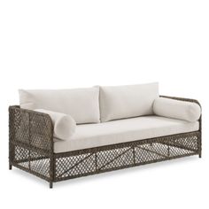 an outdoor sofa with white cushions and pillows on it's back end, against a white background