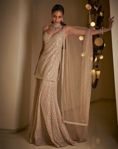 This sharara set features all-over sequin embroidery on a champagne net base. The strappy top is paired with a matching net dupatta.From Seema Gujral's Fiori collection. DELIVERY TIMEPlease allow 8-12 weeks for your outfit to arrive. FABRIC DETAILSNet Professional cleaning only. Champagne Indian Outfit, Velvet Indian Outfits, Sequin Sharara, Sharara Kurti, Function Outfit, Dupatta Collection, Indian Fits, Wedding Fits, Seema Gujral