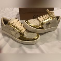 Maker’s Brand Women’s Gold And Cream With Silver Star Sneakers, Style Meil 29. Size 6. New In Box. A Light Weight Sneaker, Synthetic Leather With Padded Insole. Bought At Francesca’s. Color Marked Nude On Box But It’s More Of A Cream Color. Gold Sneakers With Perforations, Gold Low-top Sneakers With Perforations, Gold Sneakers With Speckled Midsole And Round Toe, Star Sneakers, Cream And Gold, Silver Stars, Synthetic Leather, Womens Shoes Sneakers, Cream Color