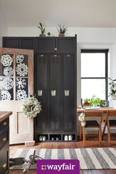 a room with black lockers and plants on the top shelf in front of it