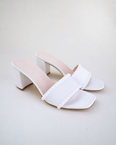 "Classic satin slip on block heel sandals adorned with pearls on the vamp for romantic, elegant and feminine look. The delicate pearl beads are placed carefully by hand to create a graceful classic style. Simple and easy wear for bridal wear, bridesmaids, holiday party, wedding parties, and any special occasions.  DETAILS: HEEL HEIGHT: 2.5 Inches COLORS AVAILABLE: Ivory and White UPPER: Synthetic upper and lining MATERIALS: Manmade outsole STYLE NAME: VERONA Not sure of which size to purchase? Shoes measurements are as follow: (Please note measurements taken the length of inside of shoe from toe to heel) Size 5.5 - 9\" Size 6 - 9.25\" Size 6.5 - 9.375\" Size 7 - 9.5\" Size 7.5 - 9.625\" Size 8 - 9.75\" Size 8.5 - 9.875\" Size 9 - 10.125\" Size 10 - 10.375\" Size 11 - 10.75\" - We DO NOT of Cheap White Sandals With Block Heel, Luxury White Block Heels For Party, White Small Heel Sandals, Pearl Open Toe Wedding Shoes For Formal Occasions, Formal Open Toe Pearl Wedding Shoes, Formal Pearl Open Toe Wedding Shoes, White Pearl Embellished Wedding Shoes For Bridesmaids, Summer Wedding Pearl Heels, Elegant Pearl-embellished Open Toe Sandals