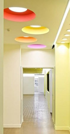 an empty hallway with several circular lights hanging from it's ceiling above the doorway