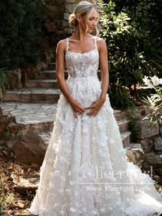 a woman in a white wedding dress standing on some steps and looking at the camera