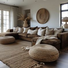 a living room filled with furniture and large windows