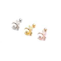 three pairs of gold, silver and diamond ear studs with crescent design on them