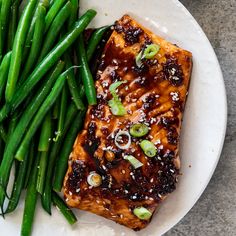 a white plate topped with green beans and tofu