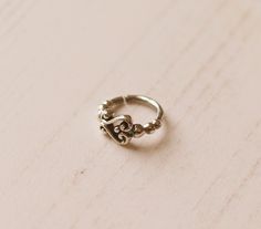 Sterling Silver ring, appropriate for a variety of different piercings. Suitable for a nose ring, ear tragus, daith, septum, rook, helix or as an ear jewellery. The wire width is 1mm thickness and with 8mm width diameter wearable inside.  The way to open is gently twisting sideways and close the same way backwards. Simple silver hoop featuring a swirly ornate design. - Colour: Silver  - Material: 925 Sterling Silver - Diameter: wearable inside: 8mm / 0g - Wire Width/Gauge: 1mm / 18g - Sold individually We ship worldwide from Brighton, UK. Nose Piercing Silver, Different Piercings, Rose Gold Nose Ring, Jewelry Nose Rings, Ear Jewellery, Tragus Daith, Hamsa Jewelry, Nose Bones, Silver Nose Ring