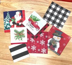 several christmas cards laid out on a wooden floor with snowman, santa clause and truck