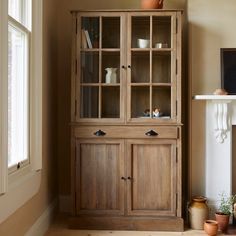 a wooden cabinet sitting next to a fireplace in a living room