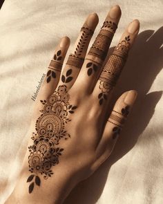 a woman's hand with henna tattoos on it