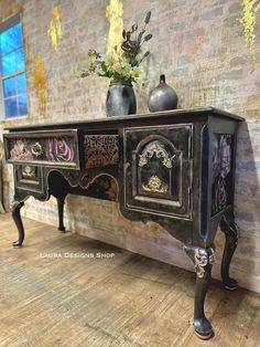 an ornate black sideboard with two vases on it