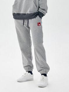 This is an trendy jogger pants in an oversized silhouette that you can wear comfortably. These are a comfortable and wearable item that is good to match with various items.  - Cotton material- Banding and string on waist- Graphic embroidery design on the front- Sturdy hemline at the bottom as a refined touch Gray Sweats With Elastic Waistband For Streetwear, Gray Sportswear Sweatpants For Loungewear, Gray Leisure Bottoms With Ribbed Cuffs, Gray Casual Sweats For Leisure, Gray Sweats With Elastic Waistband For Jogging, Casual Gray Joggers With Elastic Cuffs, Gray Athleisure Joggers With Elastic Cuffs, Gray Loungewear Pants With Elastic Cuffs, Gray Sportswear Sweats With Elastic Waistband