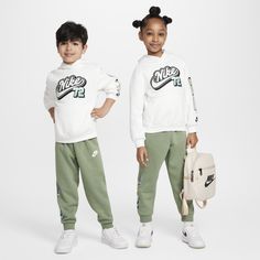 Step up your kiddo's style game with this eye-catching 2-piece set, made of soft cotton/poly fleece. The hoodie has a roomy cut for easy layering over a tee or tank for extra warmth, slightly dropped shoulders create a relaxed fit and the kangaroo pocket comes in handy. The matching pants have a comfy waistband and the tapered legs with ribbed cuffs create a cozy, secure feel little ones can play or lounge in. Casual Hoodie With Drawstring Hood For Play, Casual Drawstring Hoodie For Playwear, Casual Cotton Hoodie For Playwear, Nike Casual Streetwear Sets, Sporty White Hooded Set, White Hooded Streetwear Sets, Nike White Hoodie For Loungewear, Nike Long Sleeve Streetwear Set, White Nike Hoodie For Loungewear