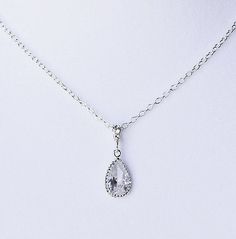 a white necklace with a tear shaped pendant