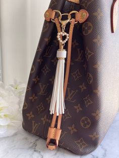 Take your favorite purse out of hibernation mode with this white faux leather tassel🤍 The perfect match to brown or neutral toned canvas bags. Accented with a beautiful pearl heart charm.  *Purses are not for sale. They are for display only to showcase the charms* Purse Charm Care💕 ✨Use as an accessory for your bag and not a keychain, as it will maintain its beauty & longevity that way✨   ✨To keep your purse charm in its best condition: ✨Avoid water, sprays and oils ✨When not using, store in a Yes Saint Laurent, Small Louis Vuitton Bag, Saint Laurent Purse, Favorite Purse, Pearl Heart, Canvas Bags, Purse Charms, Leather Tassel, Vuitton Bag