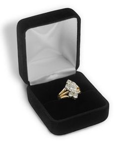 an engagement ring in a black velvet box on a white background with the lid open