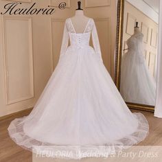 a white wedding dress on display in front of a mirror with the words helbora written