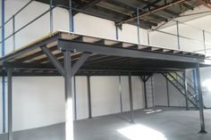 an empty warehouse with metal beams and scaffolding