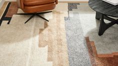 a brown chair sitting on top of a rug next to a table