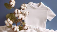 a t - shirt and cotton flowers on a bed