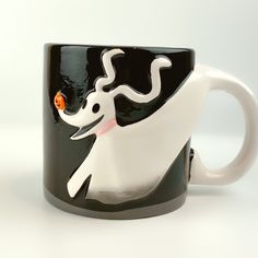 a black and white coffee mug with a cat on it