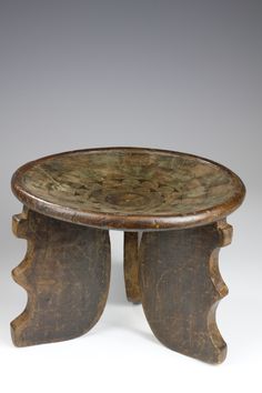 an old wooden table with two legs and a bowl on the top that has been carved into it