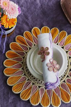 a decorative plate and napkin on a purple table cloth