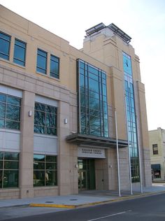 an empty street in front of a large building with windows on each side and a clock tower at the top