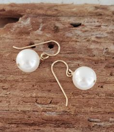 Simple swingy single white pearl earrings Pearl White Dangle Earrings For Everyday, Pearl White Drop Earrings For Everyday Wear, Everyday Pearl White Drop Earrings, Pearl White Dangle Earrings For Pierced Ears, Pearl White Dangle Earrings, Pearl White Round Earrings, Round Pearl White Earrings, Classic Hypoallergenic Drop Earrings, Classic Handmade Everyday Earrings